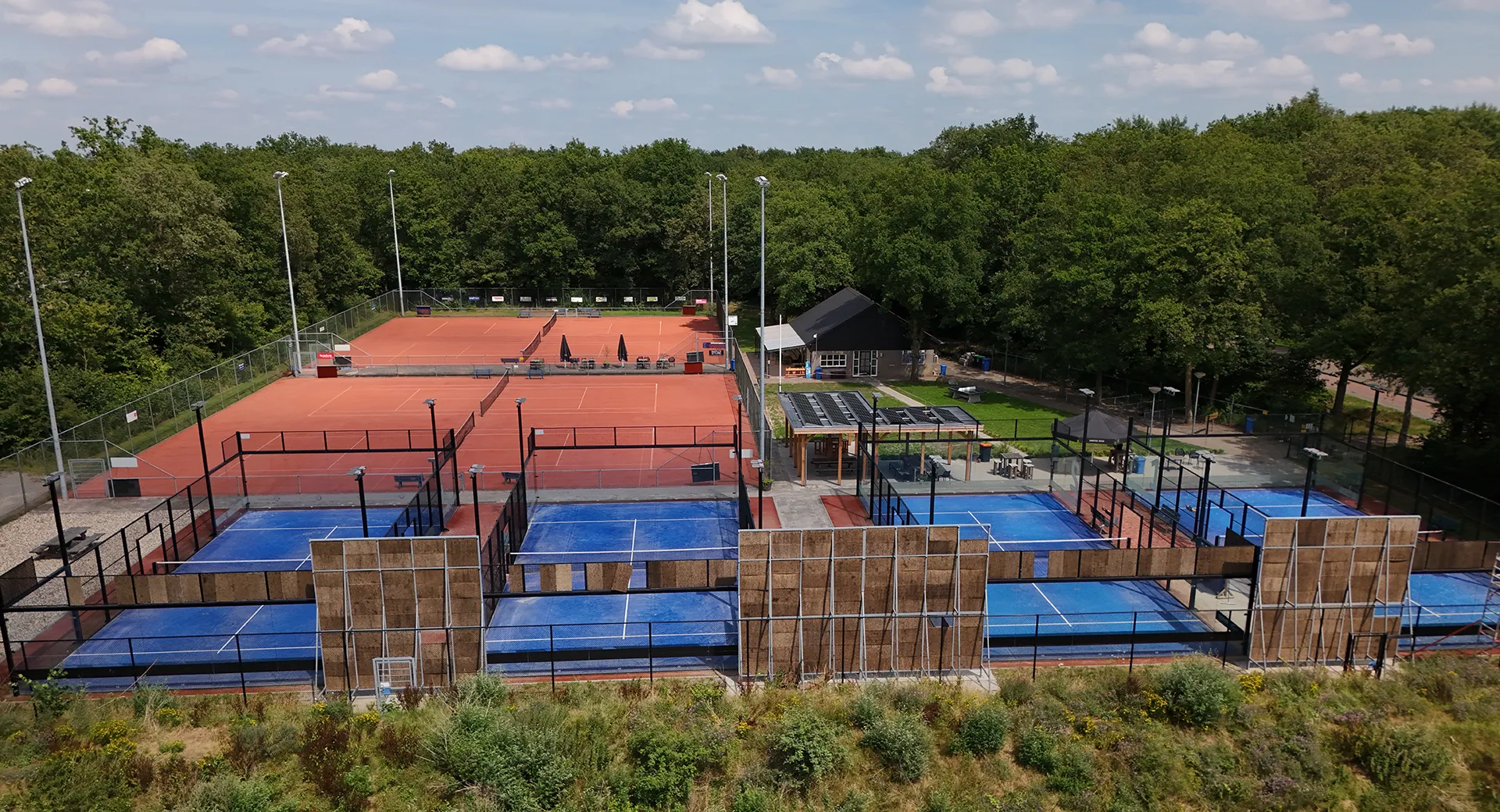 Padelspeler kijkt uit over de baan in Westerbork bij zonsopkomst
